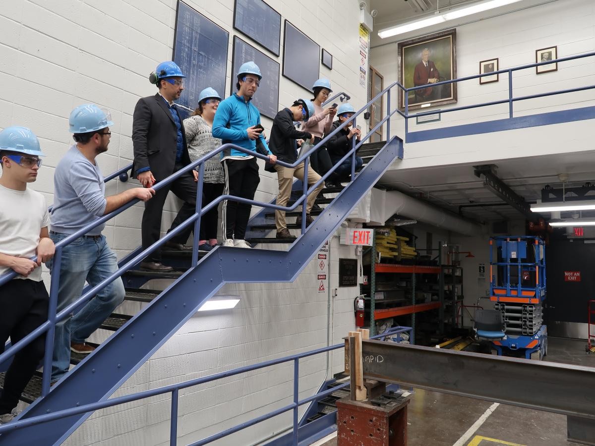 Students are observing laterial torsional bending in a beam. Students observing a buckling demo